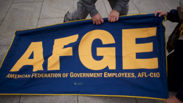 Members of the AFGE (American Federation of Government Employees) set up a banner during a protest